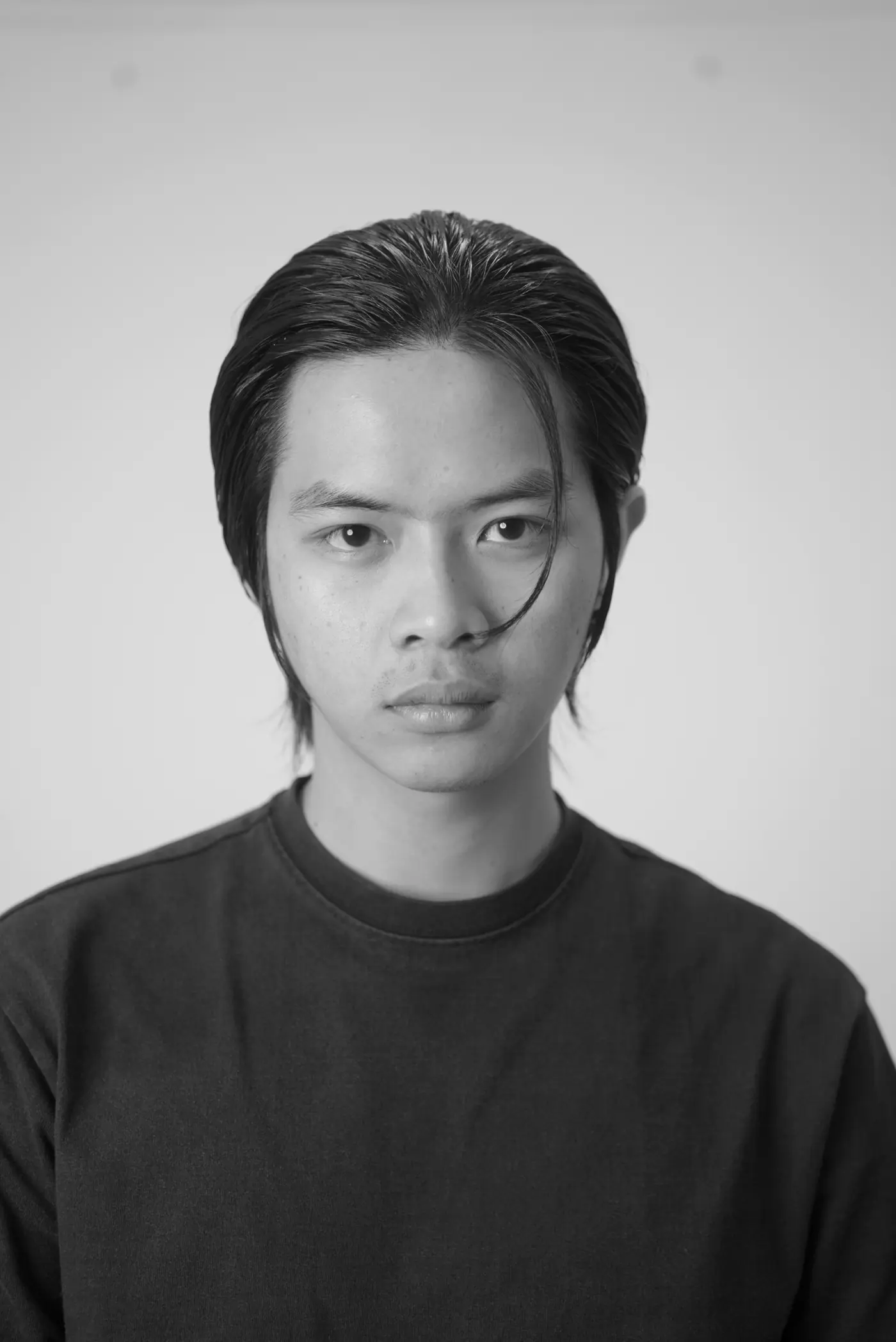 Headboss model with a long slicked-back wolf cut, black and white