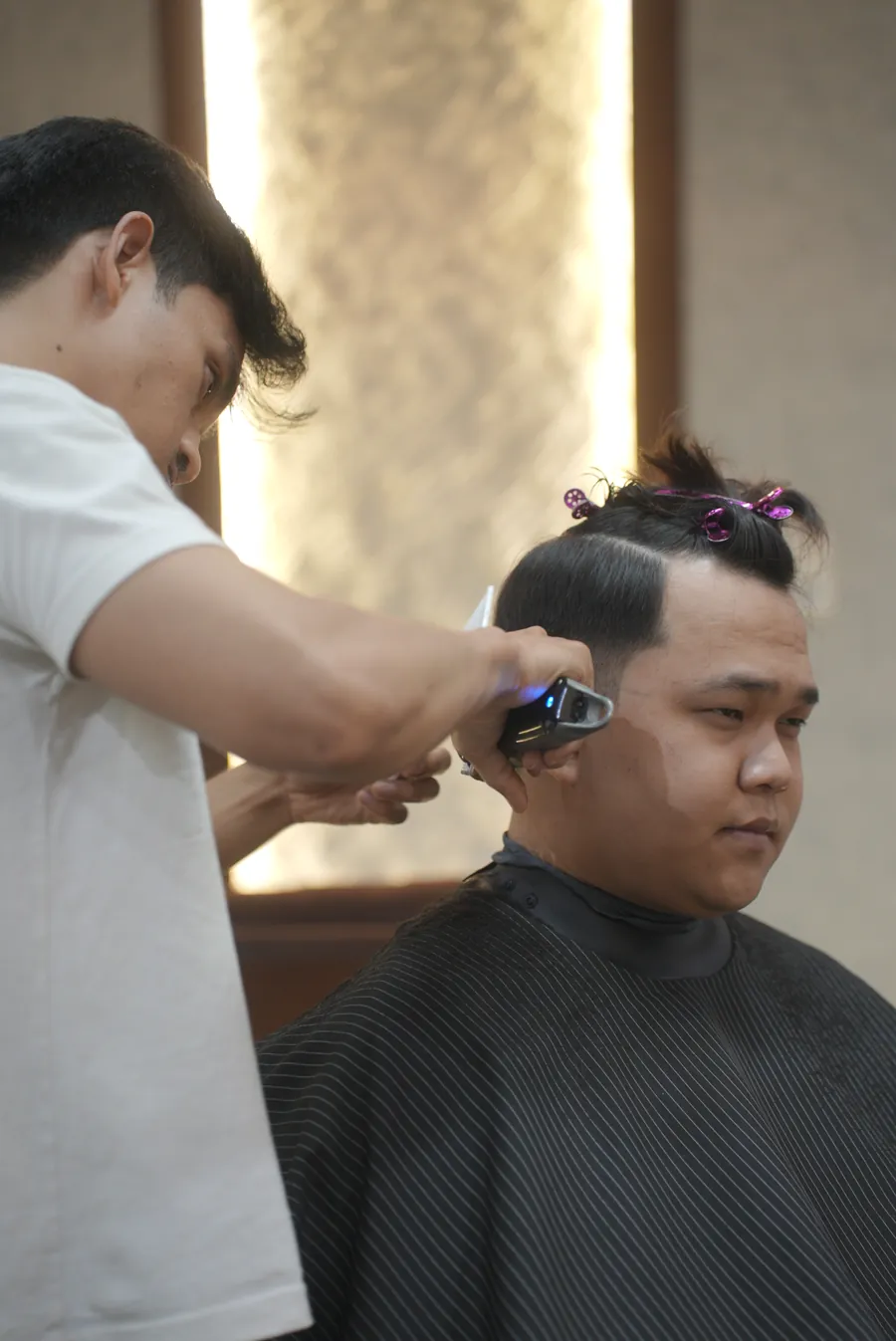 A Headboss hairdesigner fading a client&rsquo;s sides with clippers