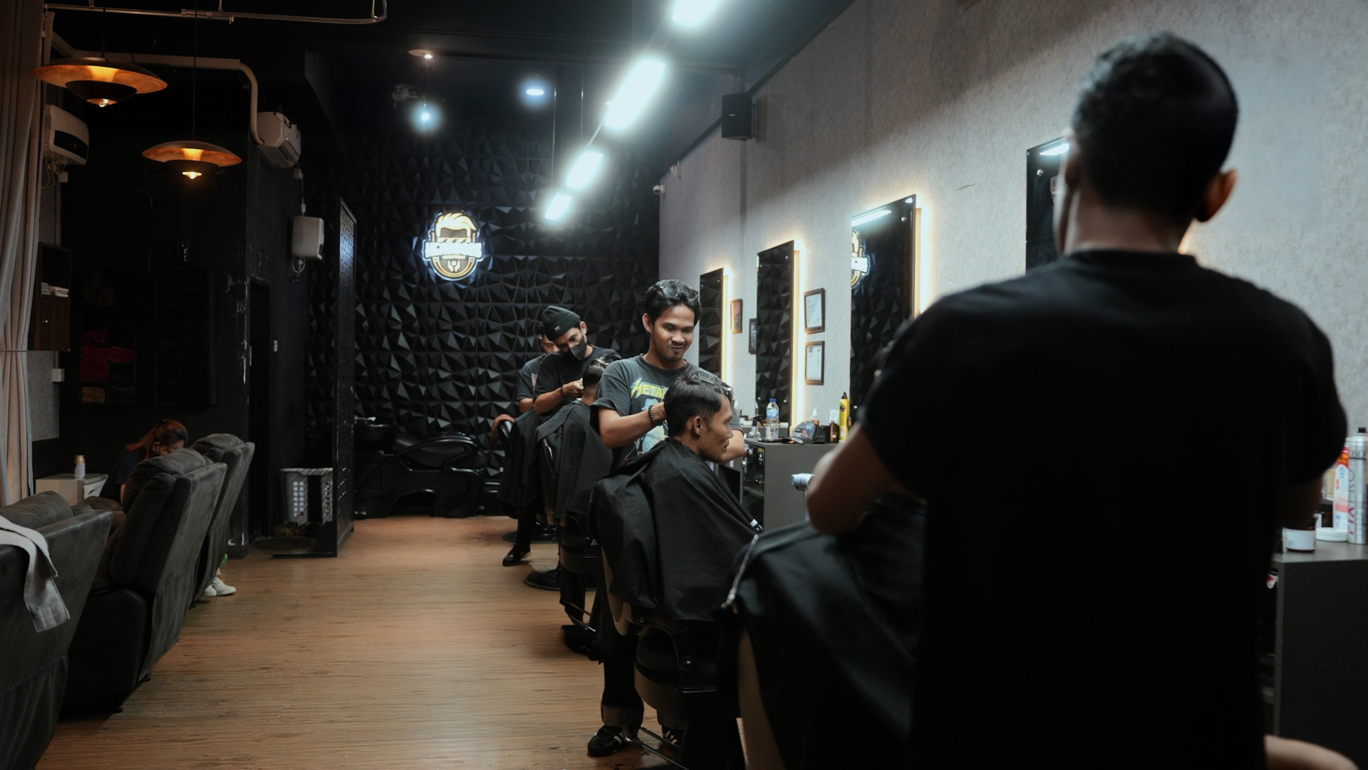 Headboss barber mid-cut, fade in progress under warm shop light